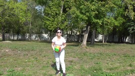 Anna is playing a ball in the park