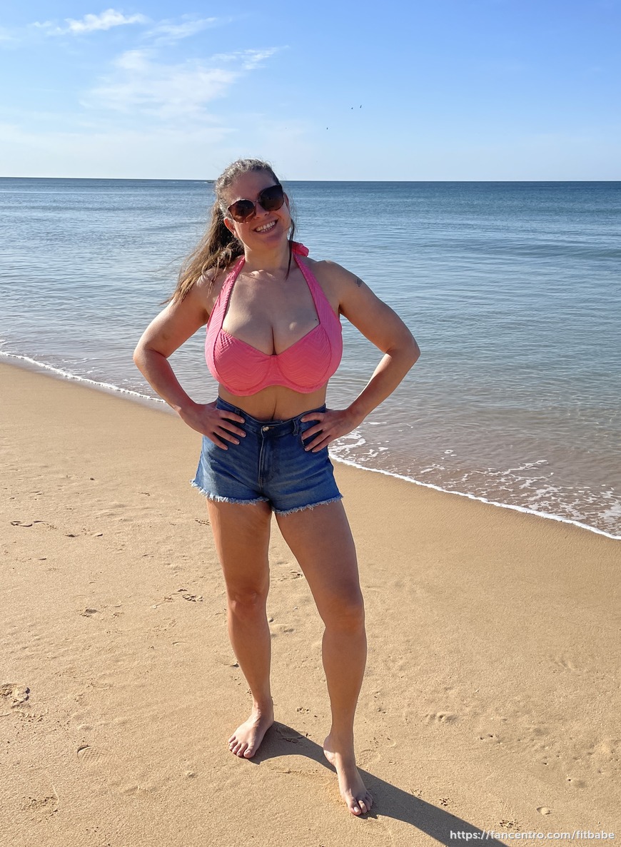 Posing on the beach in shorts and a bikini top 1